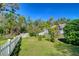 Scenic backyard with a white fence, mature trees, and lush greenery creating a serene outdoor space at 37362 Dixie Ave, Dade City, FL 33525