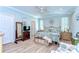 Comfortable bedroom with a decorative bed, wooden floors, a ceiling fan, and natural light from two large windows at 37362 Dixie Ave, Dade City, FL 33525