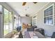 Relaxing screened-in patio offers comfortable seating, a ceiling fan, and natural light at 37362 Dixie Ave, Dade City, FL 33525