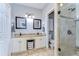 This bathroom features a double vanity with granite counters and a tiled shower with glass door at 37410 Dixie Ave, Dade City, FL 33525