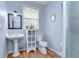 Compact bathroom features pedestal sink, window, toilet, and shower with glass door at 37410 Dixie Ave, Dade City, FL 33525