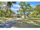 Inviting home exterior with manicured lawn, long driveway, and charming front porch, blending suburban comfort with curb appeal at 37410 Dixie Ave, Dade City, FL 33525