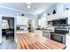 Stylish kitchen with butcher block island, stainless appliances, and a view to the living area at 37410 Dixie Ave, Dade City, FL 33525
