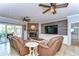 Comfortable living room featuring leather recliners, a brick fireplace, and a wall-mounted TV, creating a cozy and inviting space at 37410 Dixie Ave, Dade City, FL 33525