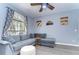 Cozy living room features a comfortable gray sectional couch, decorative curtains, and appealing wall decor at 37410 Dixie Ave, Dade City, FL 33525