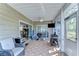 Inviting screened porch with comfortable seating, grill, and ceiling fan for outdoor enjoyment at 37410 Dixie Ave, Dade City, FL 33525
