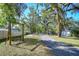 Serene property featuring a swing bench and lengthy driveway, framed by majestic trees, exuding peaceful country living at 37410 Dixie Ave, Dade City, FL 33525