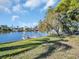 Beautiful waterfront property with a well-manicured lawn and mature trees, perfect for outdoor enjoyment at 3814 Sunray Dr, Holiday, FL 34691