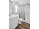 Well-lit bathroom featuring white cabinets, vanity, commode and glass door walk-in shower at 3814 Sunray Dr, Holiday, FL 34691