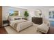 Relaxing main bedroom with a plush bed, dresser, chaise lounge, and view of the water outside at 3814 Sunray Dr, Holiday, FL 34691