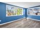 Bright sunroom featuring vibrant blue paneling and views of lush outdoor foliage at 3814 Sunray Dr, Holiday, FL 34691