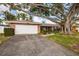 Brick home with an attached garage and a large mature tree in the front lawn at 3960 13Th Ne Way, St Petersburg, FL 33703