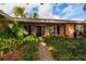 Brick home featuring lush front yard landscaping, a brick walkway, and a decorative iron porch cover at 3960 13Th Ne Way, St Petersburg, FL 33703