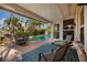 Covered patio with stylish furniture overlooking a sparkling pool and lush tropical landscaping at 3960 13Th Ne Way, St Petersburg, FL 33703
