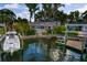 Waterfront property featuring a private dock, boat lift, and lush tropical landscaping at 3960 13Th Ne Way, St Petersburg, FL 33703