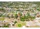 Expansive aerial view of a housing development next to a golf course with trees at 5140 Kirkwood Ave, Spring Hill, FL 34608