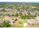 Wide aerial view showcasing a residential community beside a golf course with mature trees at 5140 Kirkwood Ave, Spring Hill, FL 34608