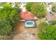 Aerial view of a property with a pool, screened-in patio, and landscaped grounds at 5140 Kirkwood Ave, Spring Hill, FL 34608