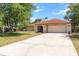 Front view of home featuring two-car garage, a well-maintained lawn and front entrance at 5140 Kirkwood Ave, Spring Hill, FL 34608