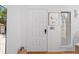 Bright white front door with multi-paneled design, sidelight window, and contemporary artwork on the wall at 5140 Kirkwood Ave, Spring Hill, FL 34608