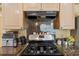 This kitchen features an updated range and hood with granite countertops at 5140 Kirkwood Ave, Spring Hill, FL 34608