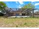 Spacious backyard pool and enclosure with lounge chairs and meticulous landscaping at 5140 Kirkwood Ave, Spring Hill, FL 34608