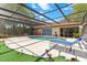 Inviting screened-in pool with lounge chair, outdoor dining set, and lush backyard at 5140 Kirkwood Ave, Spring Hill, FL 34608