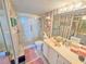 Bathroom features a glass-enclosed shower, light pink striped wallpaper, and a large mirror above the sink at 6020 Shore S Blvd # 902, Gulfport, FL 33707