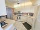 Well-lit kitchen featuring tile floors, white appliances, and ample cabinet space for storage at 6020 Shore S Blvd # 902, Gulfport, FL 33707
