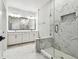 Modern bathroom with marble-look tile, frameless glass shower, and double sink vanity at 6605 N Nebraska Ave # 28, Tampa, FL 33604