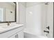 Bright bathroom featuring a white tiled shower/tub, and white vanity with dark trim at 6605 N Nebraska Ave # 28, Tampa, FL 33604