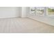 Bright bedroom featuring a light colored patterned carpet, white walls, and bright sunlight through windows at 6605 N Nebraska Ave # 28, Tampa, FL 33604