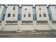 Townhome with light blue accents, multiple windows, and individual garage doors at 6605 N Nebraska Ave # 28, Tampa, FL 33604