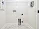 Practical laundry room with marble tile, built-in connections, and a wire shelf at 6605 N Nebraska Ave # 28, Tampa, FL 33604