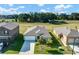Aerial view of a single-story home, landscaped yard, and green neighborhood with nearby park and other single-story homes at 6727 Bar S Bar Trail, Zephyrhills, FL 33541