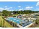 Stunning aerial view of a community pool with inviting lounge areas and lush landscaping at 6727 Bar S Bar Trail, Zephyrhills, FL 33541