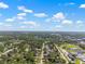 Expansive aerial view of a suburban area featuring a lake and a distant cityscape with a red pin at 7401 Hancock St, Riverview, FL 33578