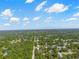 Extensive aerial view capturing a green suburban landscape stretching towards the horizon under a partly cloudy sky, with a red pin at 7401 Hancock St, Riverview, FL 33578