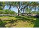 Wide shot of backyard, with a lawn and mature trees at 7401 Hancock St, Riverview, FL 33578