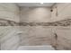 Bathroom showcasing a tub with tiled walls and mosaic accents, and a shower head at 7401 Hancock St, Riverview, FL 33578