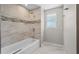 Bathroom featuring tile walls, a bathtub, and a showerhead with excellent lighting at 7401 Hancock St, Riverview, FL 33578