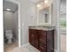 Charming bathroom with a granite countertop vanity, dark wood cabinets and adjacent toilet area at 7401 Hancock St, Riverview, FL 33578