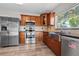 Well-lit kitchen showcasing stainless steel appliances and wooden cabinetry at 7401 Hancock St, Riverview, FL 33578