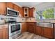 Beautiful kitchen with stainless steel appliances, wooden cabinets, and a window view at 7401 Hancock St, Riverview, FL 33578