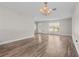 Spacious living room featuring hardwood flooring, elegant chandelier, and bright natural light at 7401 Hancock St, Riverview, FL 33578