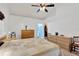 Light-filled bedroom with ceiling fan, soft carpet, and an ensuite bathroom at 7607 Wiltshire Park Pl, Apollo Beach, FL 33572