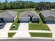 Overhead view of a well-maintained home with a lush lawn, situated between two similar houses at 8352 Greenway Ave, Wesley Chapel, FL 33544