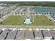 An aerial view shows the community layout with homes, green spaces, and a community pool with cabanas at 8352 Greenway Ave, Wesley Chapel, FL 33544