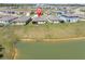 Aerial view of a community with a picturesque pond, homes are surrounded by well-maintained lawns at 8352 Greenway Ave, Wesley Chapel, FL 33544