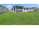 Spacious backyard featuring a screened-in patio, lush green lawn, and well-maintained landscaping at 8352 Greenway Ave, Wesley Chapel, FL 33544